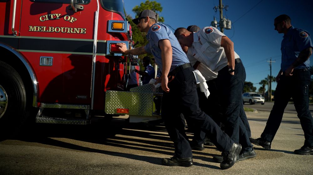 Firefighters pushing new heavy rescue into station