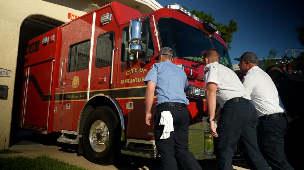 Firefighters pushing new heavy rescue into station