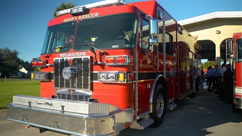 Front of Melbourne Fire Department Heavy Rescue with Station 76 and firefighters in the background