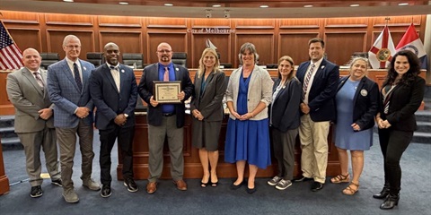 Mayor Alfrey holds the FCCMA certificate with fellow Council members, City staff, Suzanne Sherman in the Council chamber. 
