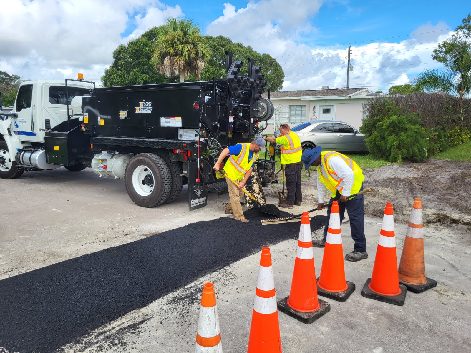 Three city employees repairing a road