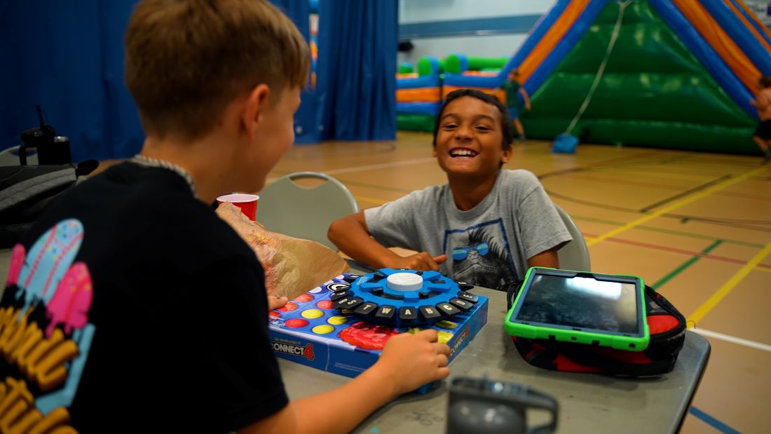 Two boys playing board games inside Wickham Park Community Center