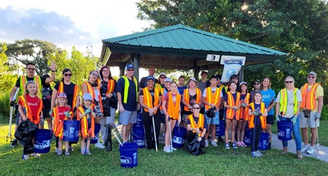 Group of ICC volunteers wearing safety vests and holding buckets and grabbers