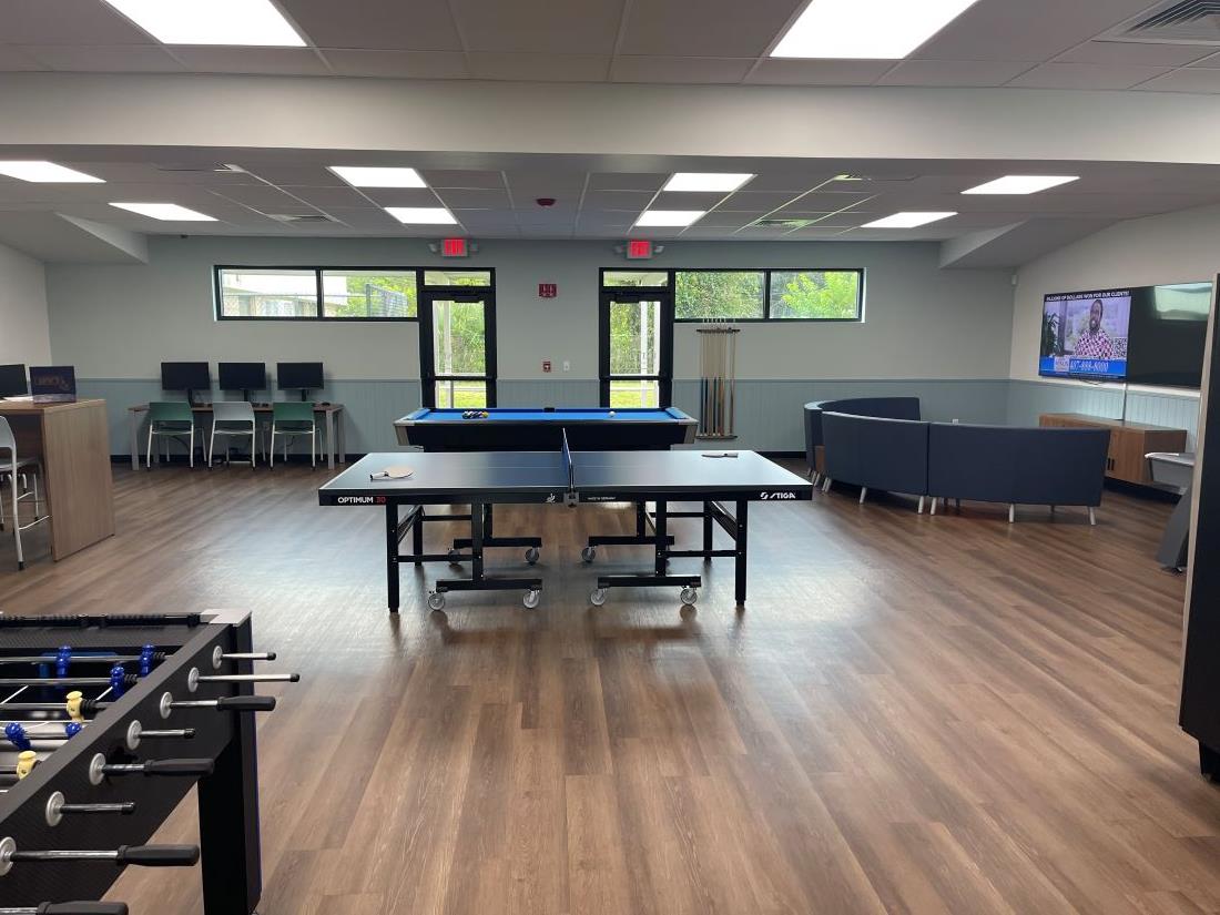 Newly renovated game room at Joseph N. Davis Community Center with computer tables and chairs, pool table, ping pong table, foosball table, large screen TV and seating area.