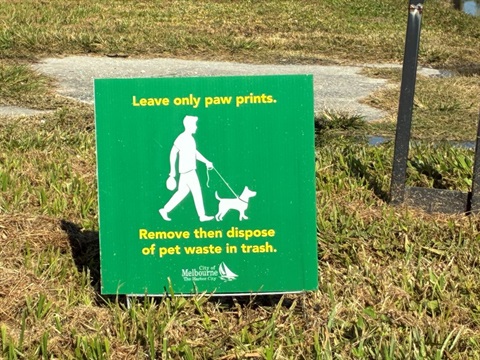 Sign placed in a grassy area that says 