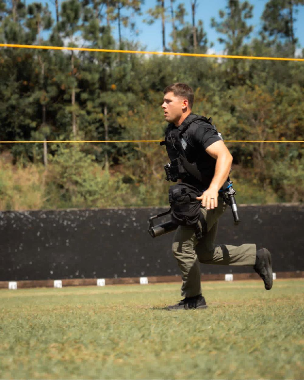 Officer running outside with gear