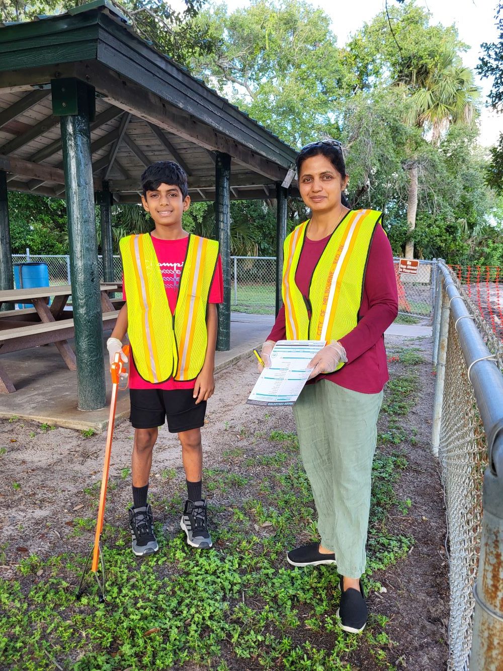 Two ICC volunteers one holding a grabber the other a clipboard