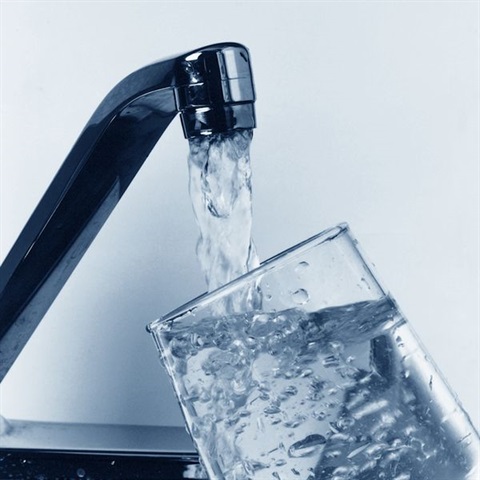 Water pouring from a faucet into a glass