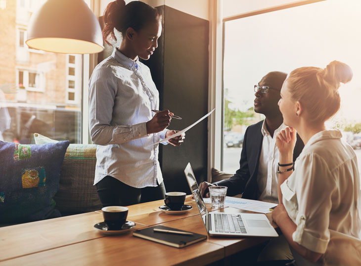 Two women and a man having a business meeting.