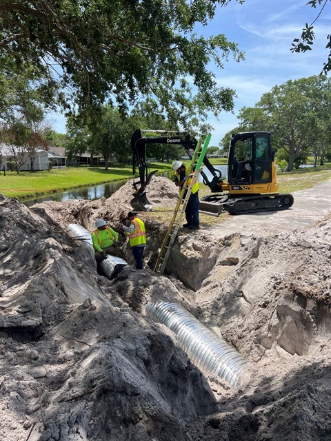 Employees installing corrugated metal storm pipe in the Sweetwood Estates Subdivision