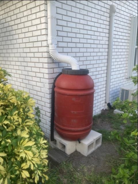 Rain barrel installed on the side of a house
